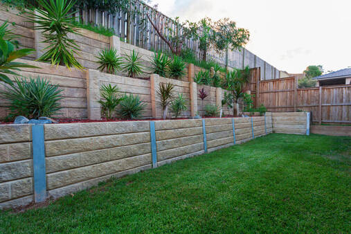 a backyard with a 3 level retaining wall system with printed concrete sleepers 